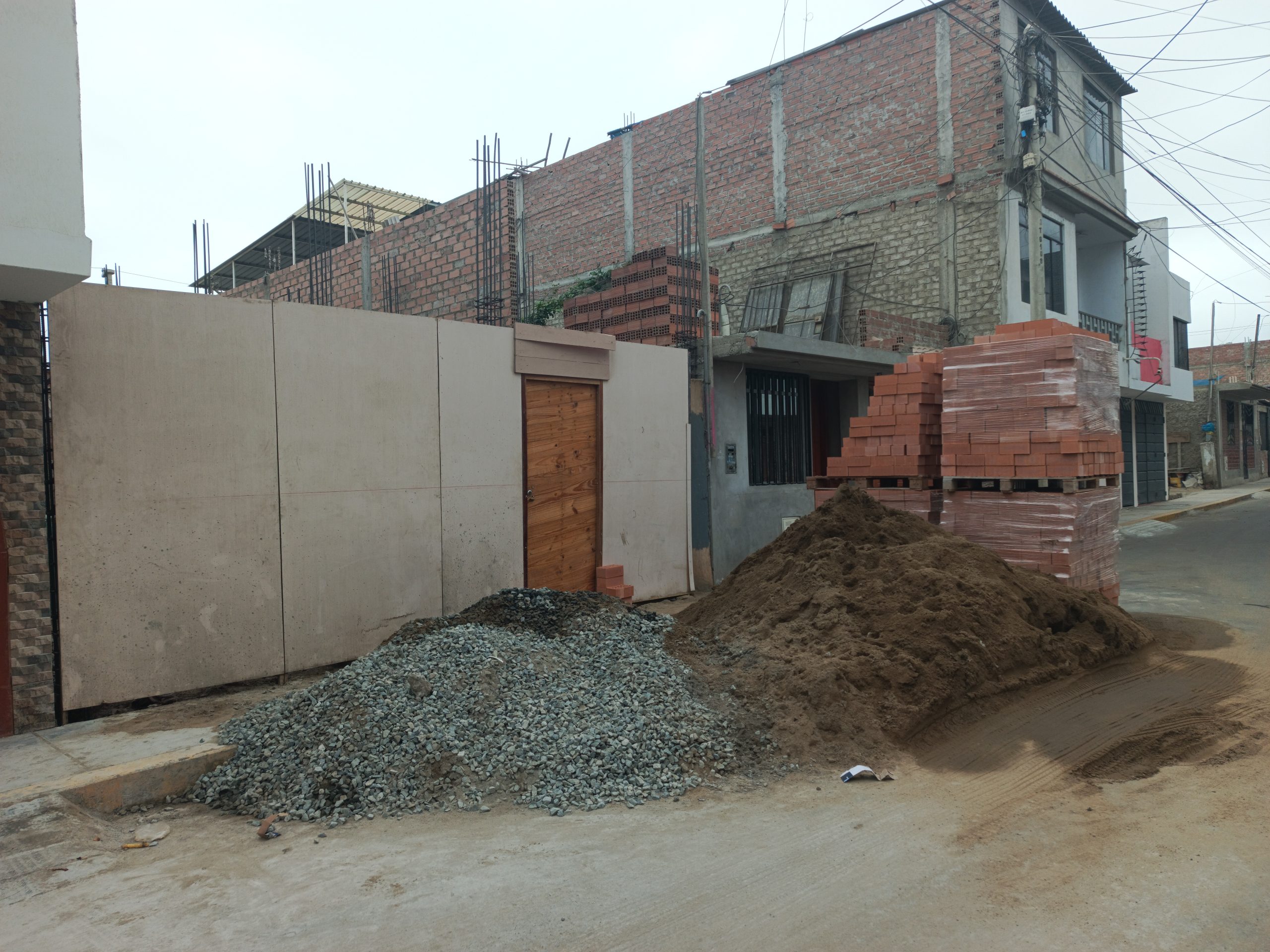 MATERIALES DE CONSTRUCCIÓN BLOQUEAN CALLES EN GARATEA: VECINOS EXIGEN SANCIONES Y ACCIONES MUNICIPALES Fachada de casa en construcción con los materiales en vía pública